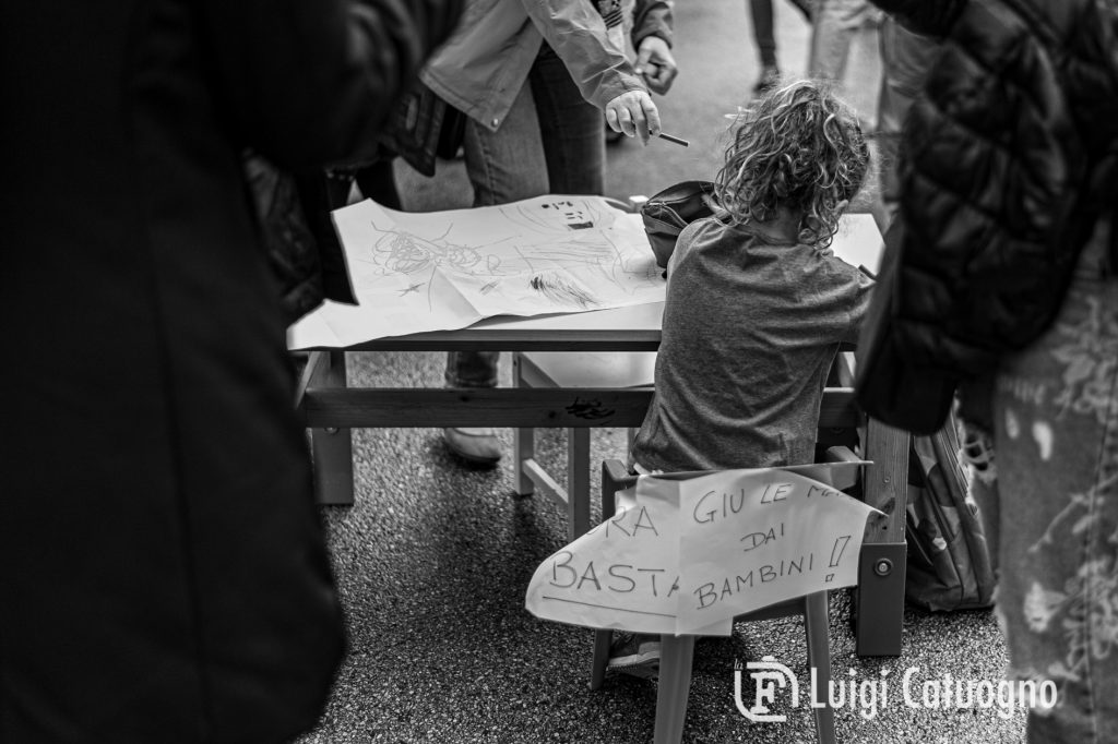 Una bambina disegna per strada. Non può farlo in classe.